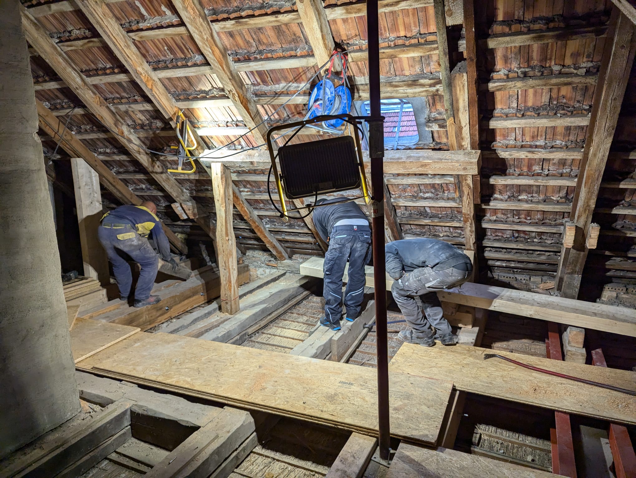 Handwerker arbeiten im geöffneten Dachstuhl an einer Dachsanierung