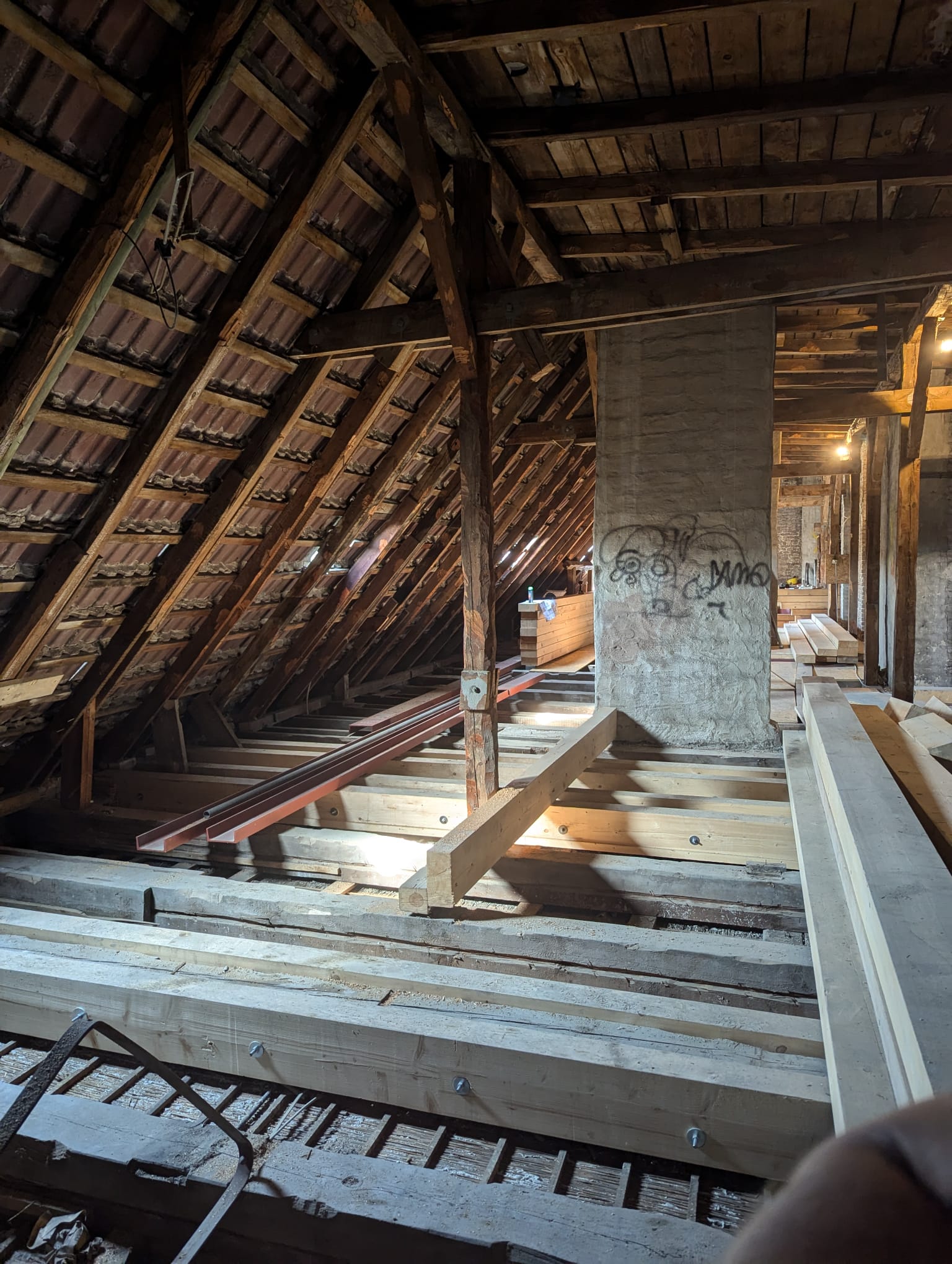 Freigelegter Dachstuhl mit Holzbalken und vorbereiteten Ausbauflächen
