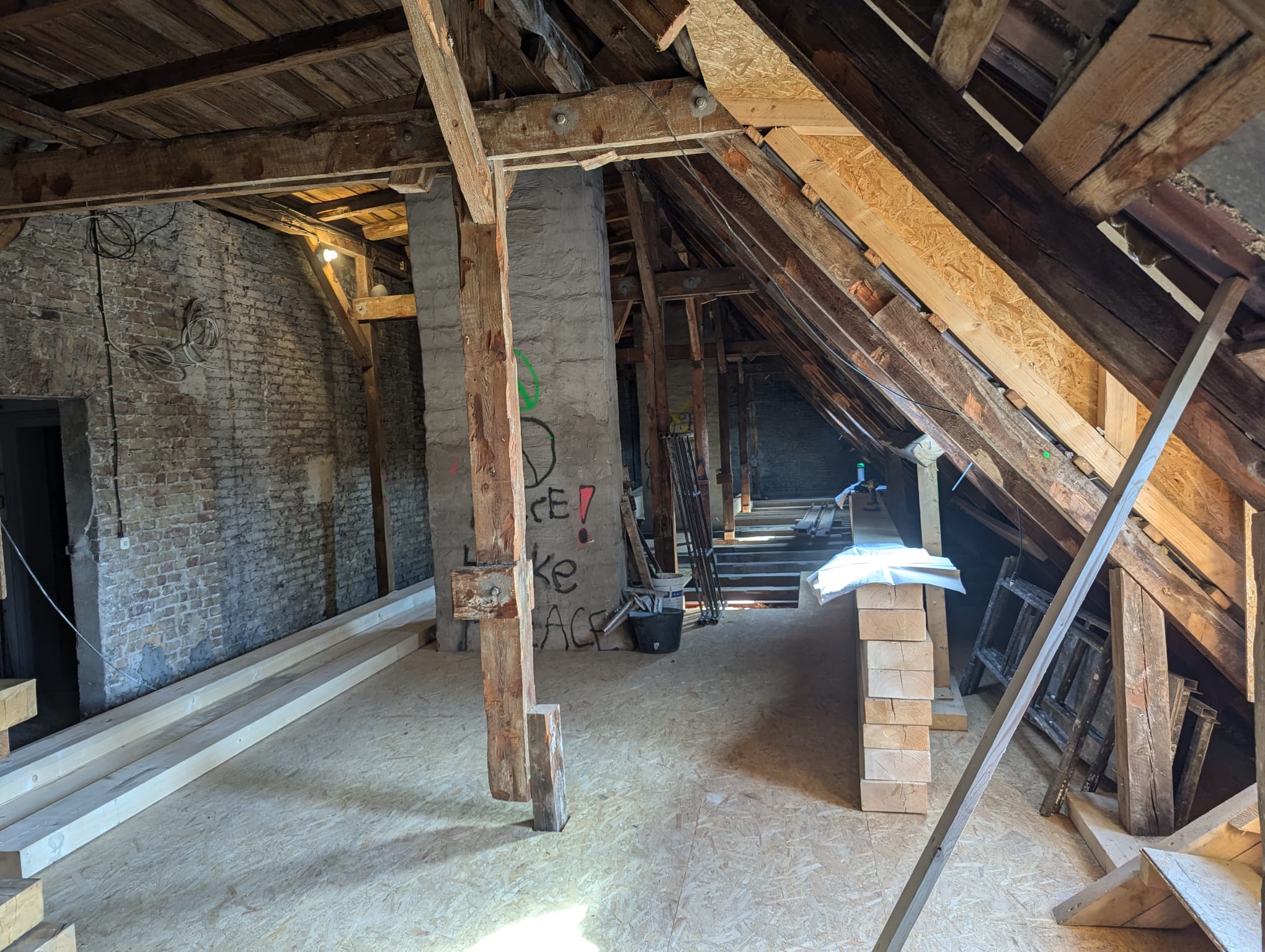 Dachgeschoss im Rohbau mit freigelegter Holzkonstruktion während der Sanierung